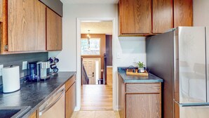 Una cocina moderna con armarios de madera, un refrigerador de acero inoxidable y una cafetera.
