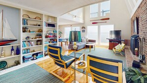 A spacious living room with a bookshelf, a television, and a fireplace. - Pool, Dock! Group Getaway on Chowan River (Merry Hill)