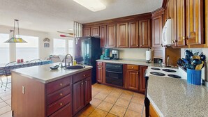 A kitchen with wooden cabinets, a granite countertop, a refrigerator, a dishwasher, and a stove. - Pool, Dock! Group Getaway on Chowan River (Merry Hill)