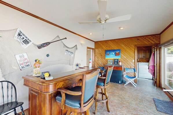 A bar area with wooden furniture, a ceiling fan, and a sign on the wall. - Pool, Dock! Group Getaway on Chowan River (Merry Hill)