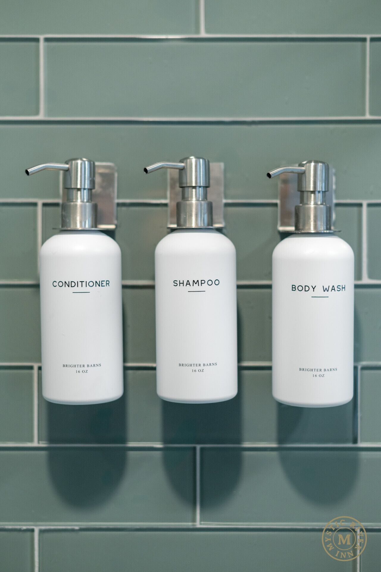 Three bottles of Brightner Barns products on a tiled wall.
