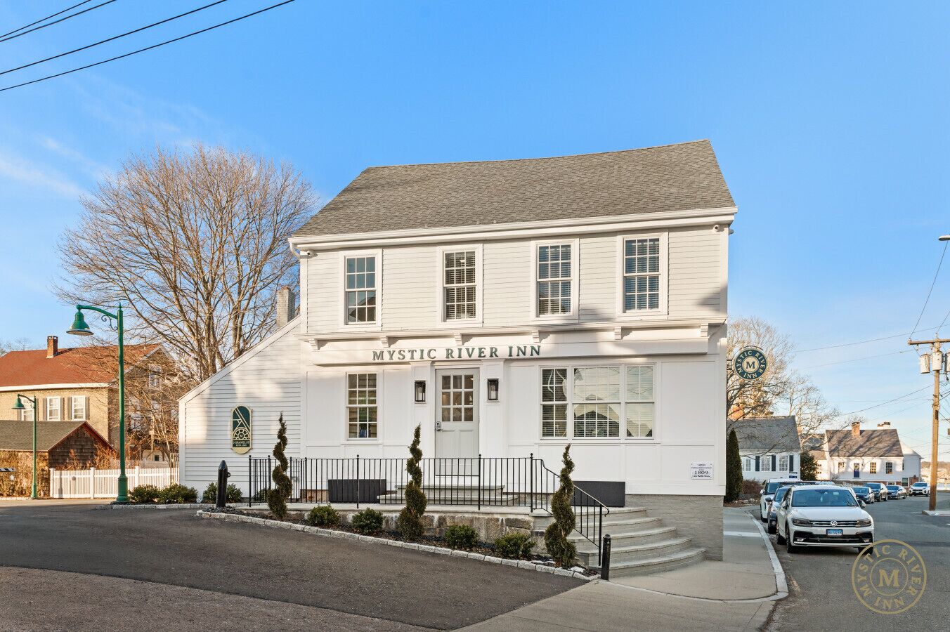A two-story building with a sign reading "Mystic River Inn."
