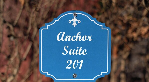 Une enseigne pour la suite 201 d’Anchor, ornée d’une bordure décorative et d’un emblème en forme de fleur de lys.