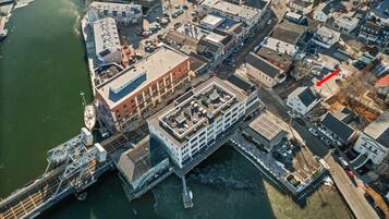 An aerial view of a waterfront area with buildings, a dock, and a bridge.