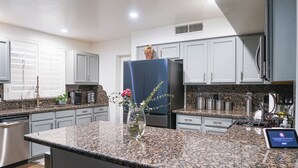 A modern kitchen with granite countertops, stainless steel appliances, and white cabinetry. - Group-Ready Glendale Oasis w/ Pool Grotto + Slide (Glendale)
