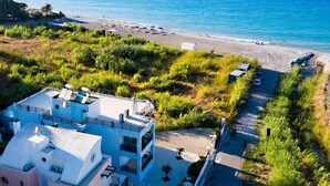 Eine Luftaufnahme einer Küstenregion mit Gebäuden, einem Strand und einer Straße, die zum Strand führt.