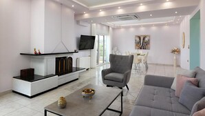 Ein modernes Wohnzimmer mit einem grauen Sofa, einem Couchtisch und einem Kamin.