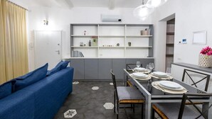 Un espai vital modern i compacte amb zona de menjador, sofà i prestatgeria.