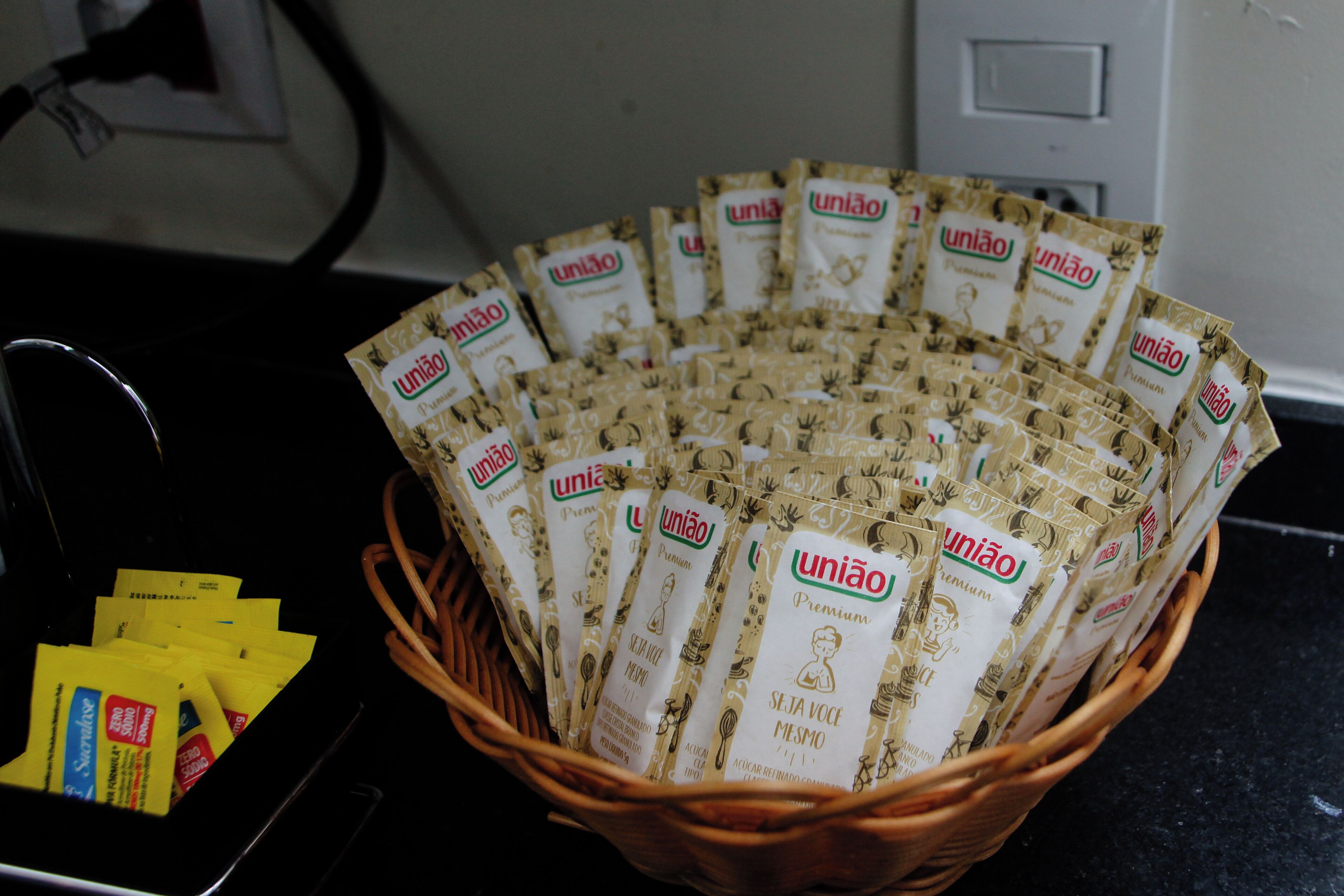 A basket filled with packets of 'União Premium' tea, placed on a kitchen counter.