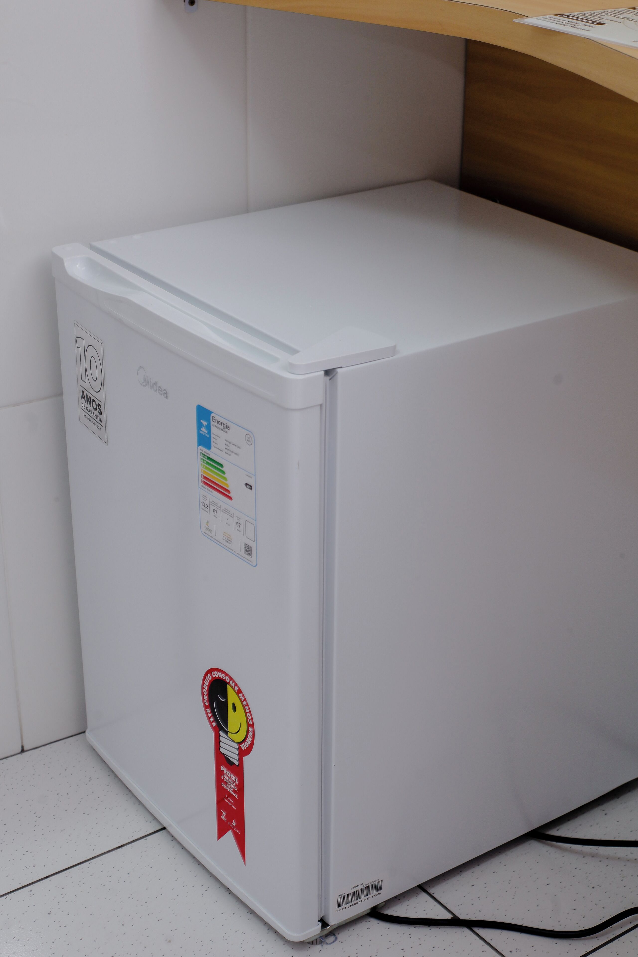 A white refrigerator with stickers indicating energy efficiency and a 10-year warranty.