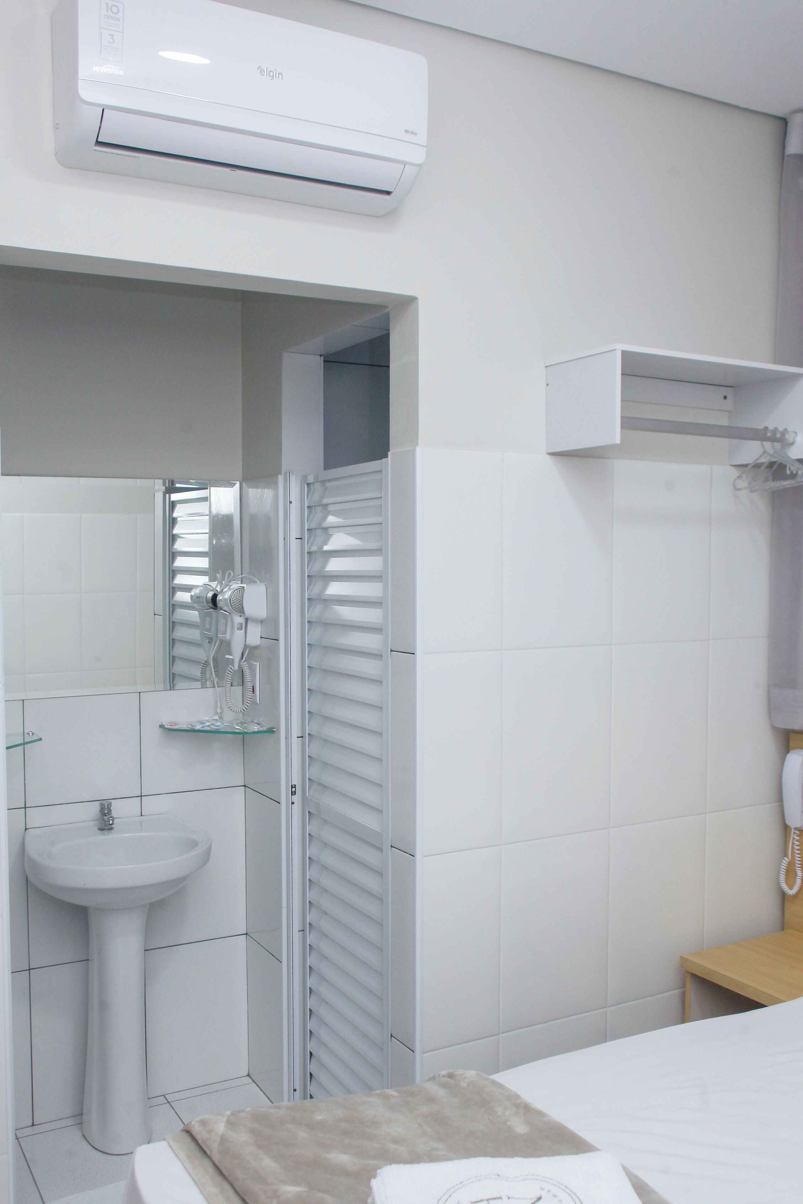 Ein Badezimmer mit einem weißen Waschbecken, einer Duschkabine aus Glas und einer weißen Toilette.
