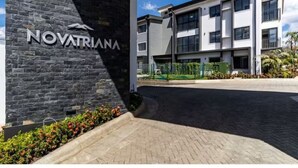 Un edificio moderno con fachada de piedra y un letrero que dice "NOVATRINA".