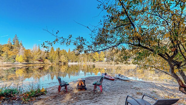 A lakeside setting with a fire pit, two chairs, and a lounge chair. - 1BR Dog-Friendly Lakefront Cabin w/ Canoes (Sonora)