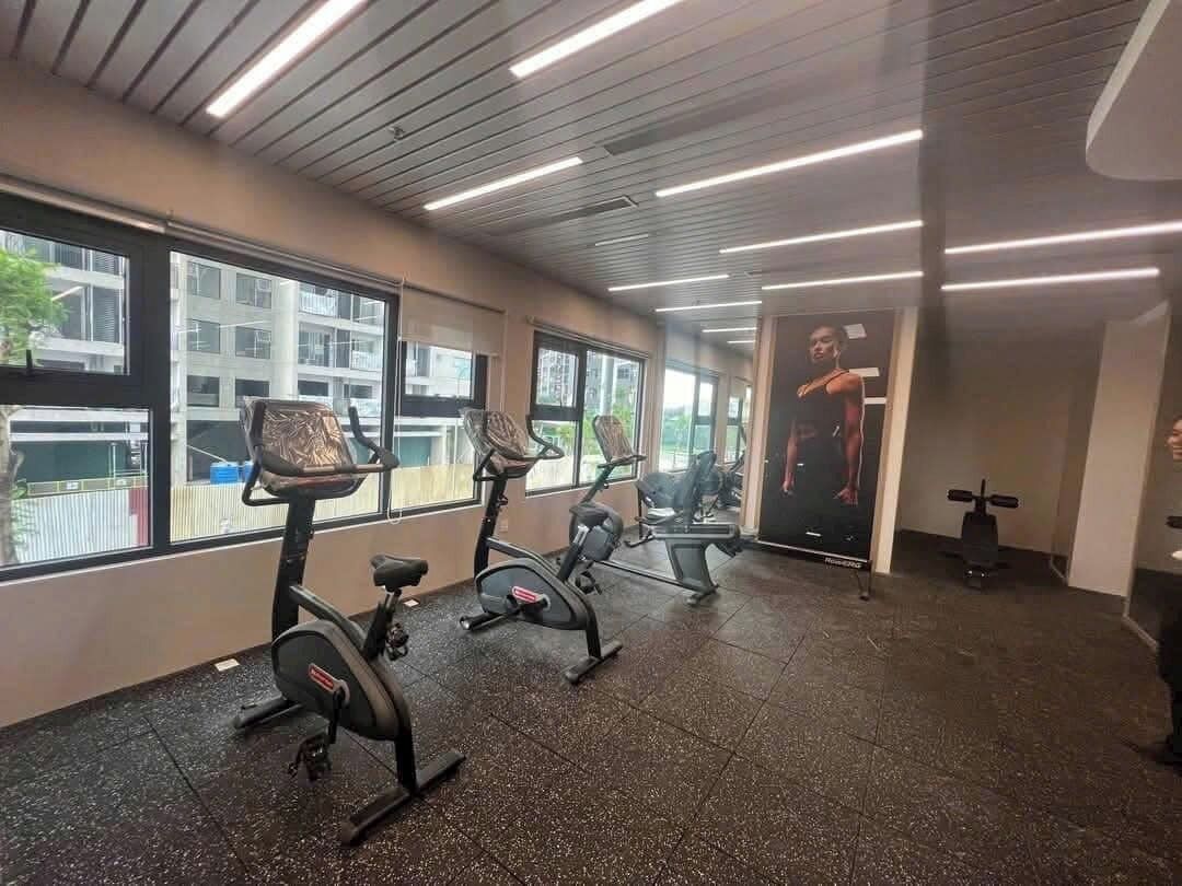 A gym with stationary bikes, a mirror, and a treadmill.