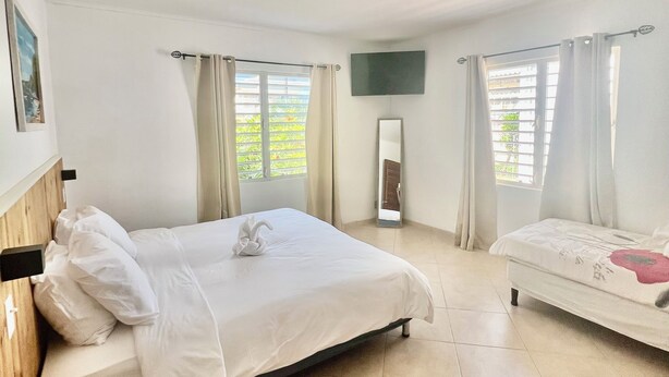 A hotel room with a large bed, a smaller bed, a flat-screen TV, and a window with curtains. - ~Nos Yemaya~ 2BR+Pool ~ Walking distance to playa Lagun! (Lagun)
