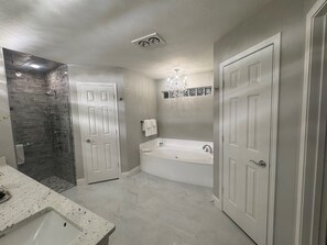 Regadera, tina de hidromasaje, bidet, toallas 