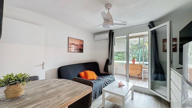 Un salon moderne avec un canapé, une table basse et un coin repas.