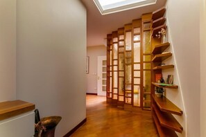 A hallway with wooden shelves, a skylight, and a wooden floor. - CAVOUR SUITE LUXURY 7, located in Galleria Cavour, Bologna's historic center. (Bologna)