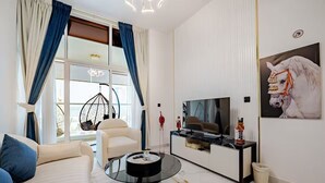 Een moderne woonkamer met een bank, salontafel, televisie en kunstwerk.