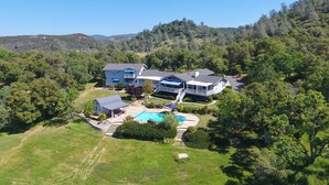A large house with a swimming pool, surrounded by lush greenery and hills. - 'Whispering Oaks Estate' w/ Pool & View in Murphys (Murphys)