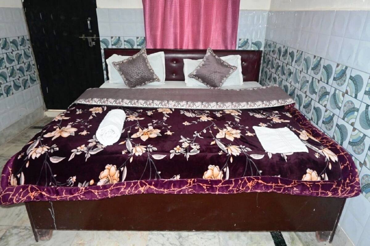 Cama com colcha floral, cabeceira e dois travesseiros.