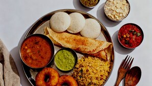 A plate of South Indian food including idlis, dosas, sambar, rice, and chutneys. - The Ayodhya Ji palace (Ayodhya)