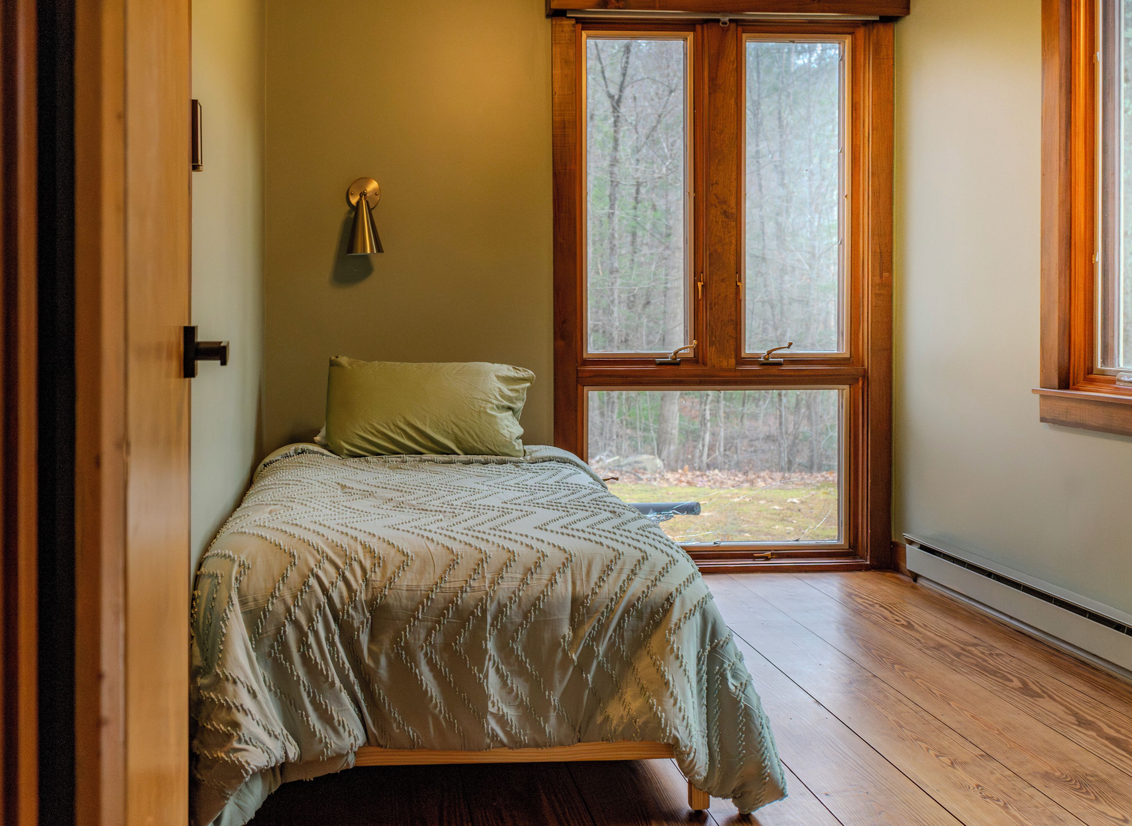 Une chambre à coucher avec un lit, une fenêtre et une porte.