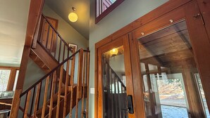 A wooden staircase leading to a second floor with a large window and a glass door. - Joia Verde: Mtn Chalet -120 Acres -Adventure Ski Hike MTB Rafting (Charlemont)
