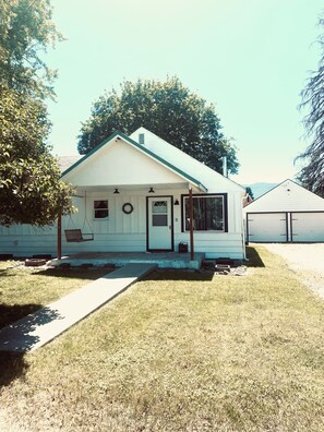A small, single-story house with a front porch, a door, and a window.