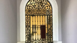 Une entrée somptueuse, agrémentée d’une arche décorative et d’un portail à barreaux.
