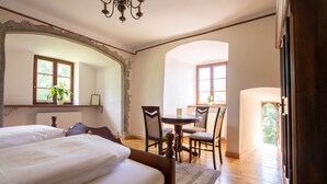 A bedroom with two beds, a dining table with chairs, and a view of the outdoors. - Hohenhardt Castle - entire castle exclusive (Wiesloch)