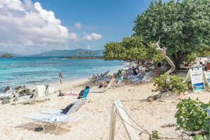 Una playa con tumbonas y un cartel que dice 'GOMOJO'.