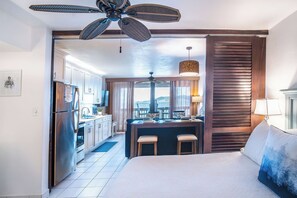 A hotel room with a bed, a kitchenette, a dining area, and a view of the mountains. - 5 ★ “Sapphire SeaView” - Direct Ocean Front at Sapphire Beach Resort & Marina (St. Thomas)