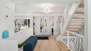 Ein moderner Flur mit Treppe, einer Sitzbank und Blick ins Freie.