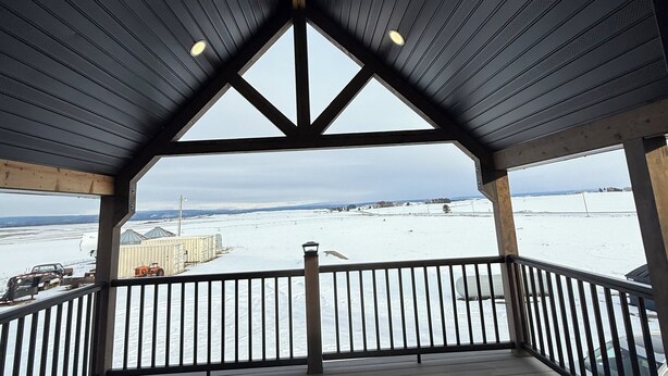 A covered outdoor area with a wooden roof and railings, overlooking a snowy landscape. - Newly renovated Ashton Farmhouse on Cave  Falls HWY. Near Yellowstone Nat. Park (Ashton)