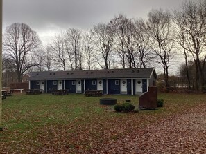 A row of numbered rooms with a covered outdoor area in front. - 4 Person Holiday Home in Ansager (Ansager)