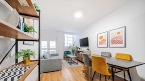 A modern living room with a dining area, wooden flooring, and a TV mounted on the wall. - Host Stay Apartment 3 Stanley Street (Liverpool)