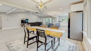 Amplia sala de estar con mesa de comedor, sillas y una lámpara moderna.