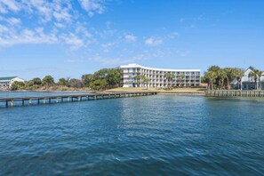 Un hotel moderno frente al agua, con varios balcones y vistas al mar.