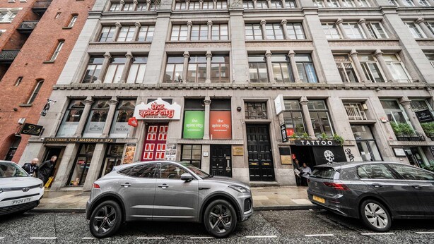 En byggnad med flera våningar som inrymmer olika verksamheter, bland annat ett massage- och spacentrum, en indisk restaurang och en tatueringsstudio.
