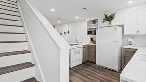 A modern kitchen with white cabinetry, a built-in oven, microwave, and refrigerator. - Townhouse Directly Across from Gulf- 2BR/2.5Ba (Panama City Beach)
