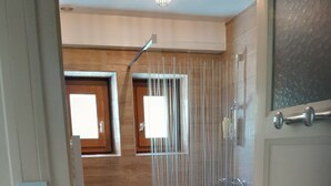 A bathroom with a shower, a sink, and a toilet.