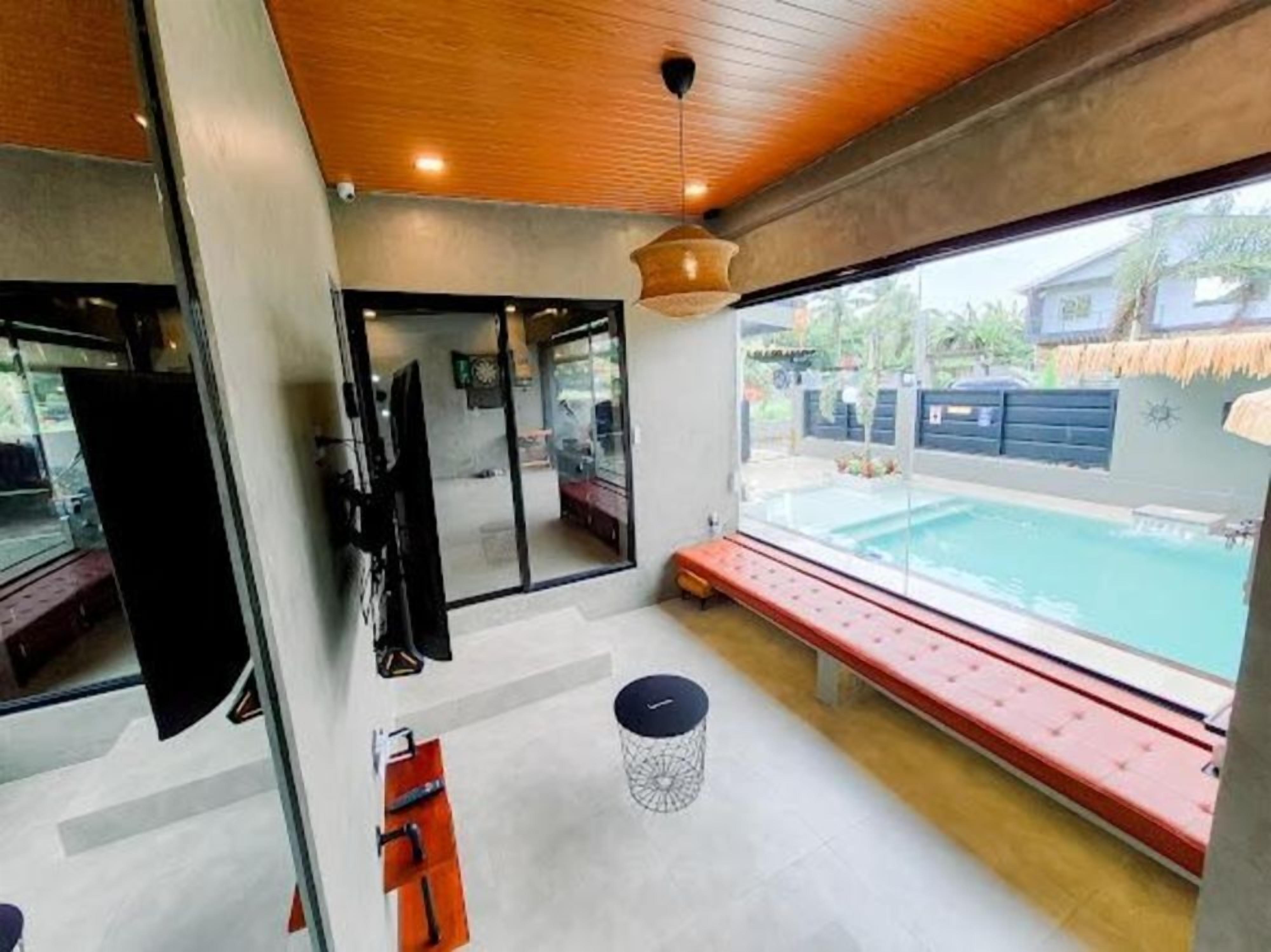 A modern interior with a pool view, a bench, and a door leading outside.
