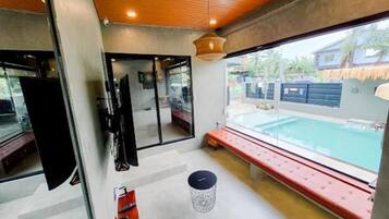 A modern interior with a pool view, a bench, and a door leading outside.