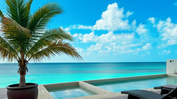 A poolside area with a palm tree, lounge chairs, and a view of the ocean. - Casa la Aurora (Puerto Morelos)