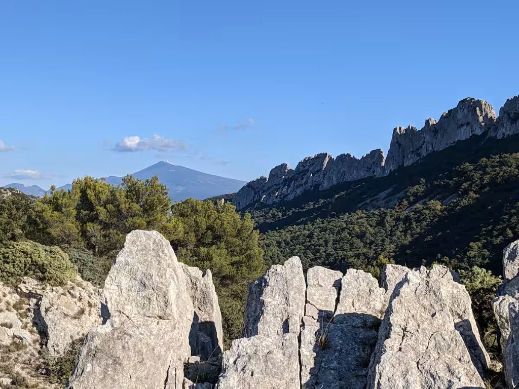 A mountainous landscape with rocky outcrops and dense forest.