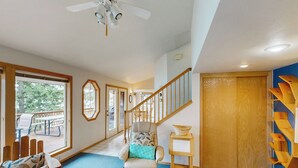 A cozy interior with a wooden bench labeled "DREAM," a cushioned chair with a blue cushion, a small table with a basket, and a staircase leading to a wooden door. - Dock, Deer Lake Access! Fishermen's Paradise (Loon Lake)