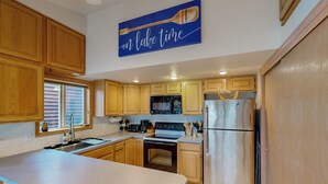 A kitchen with wooden cabinets, a stainless steel refrigerator, a microwave, and an oven. - Dock, Deer Lake Access! Fishermen's Paradise (Loon Lake)
