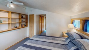 A bedroom with a bed, wooden shelves, a ceiling fan, and a nightstand. - Dock, Deer Lake Access! Fishermen's Paradise (Loon Lake)