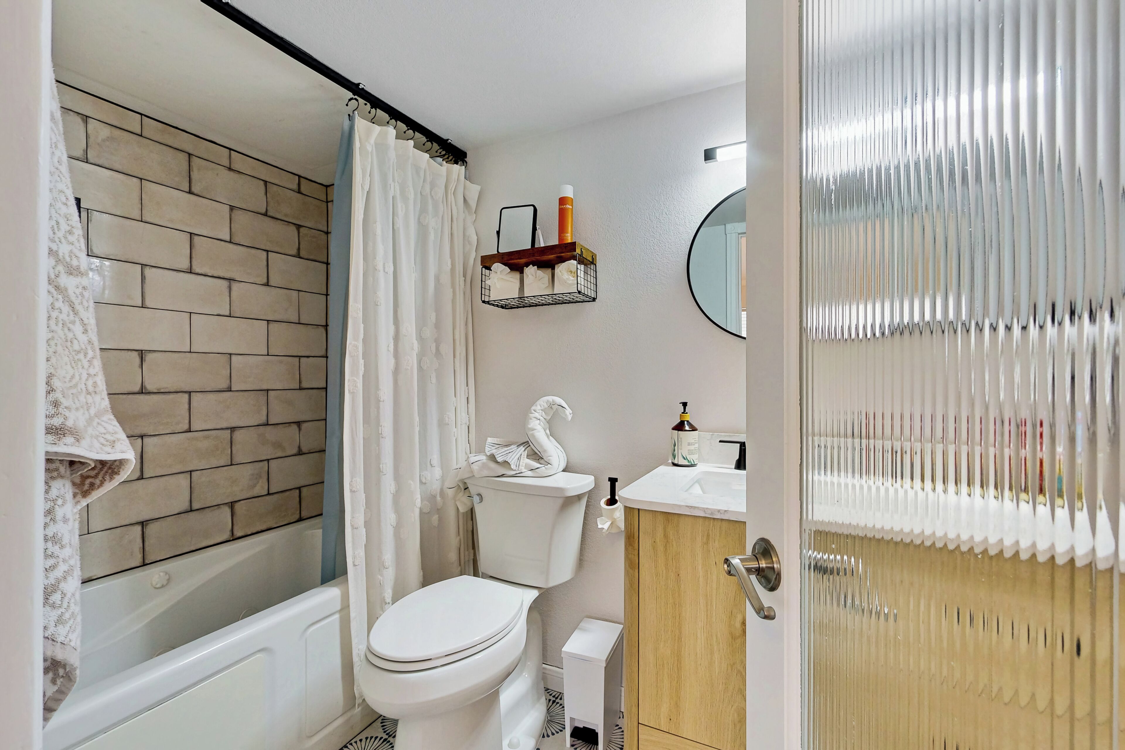 A bathroom with a bathtub, toilet, and vanity.